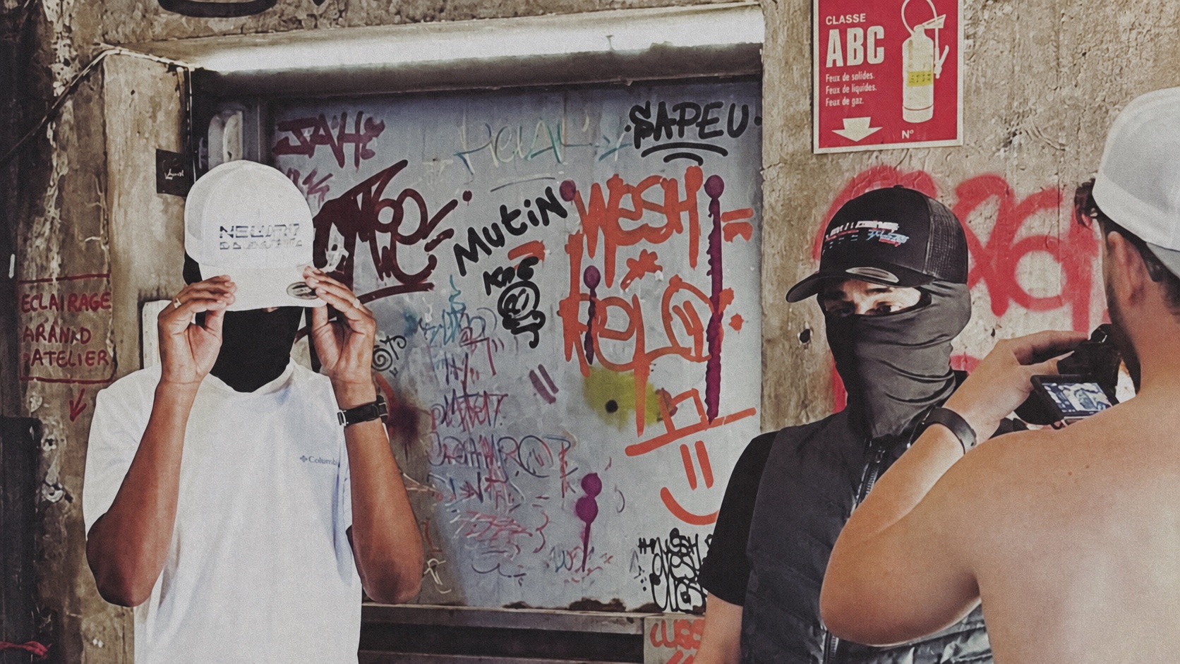 ALPHA et SNØW devant un mur couvert de graffitis